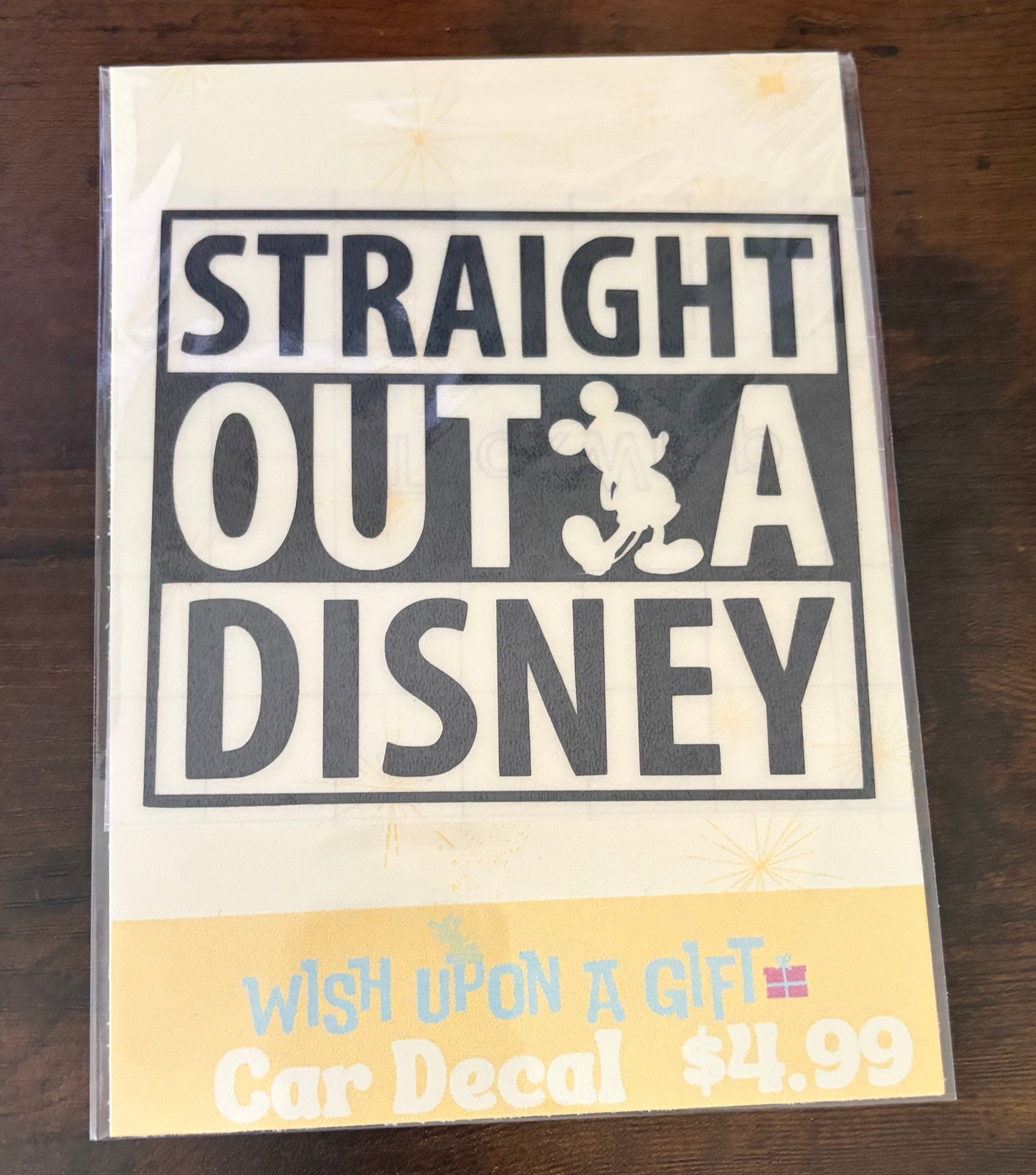 Product packaging with 'Straight Outta Disney' decal on a wooden surface