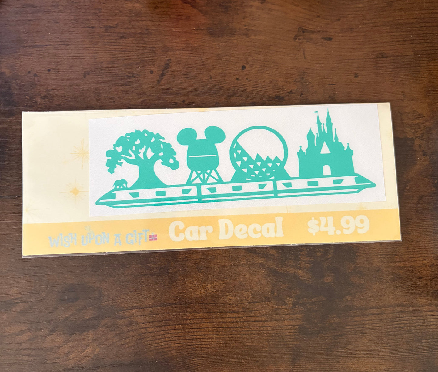Car decal packaging with graphics of disney skyline and text on a wooden surface
