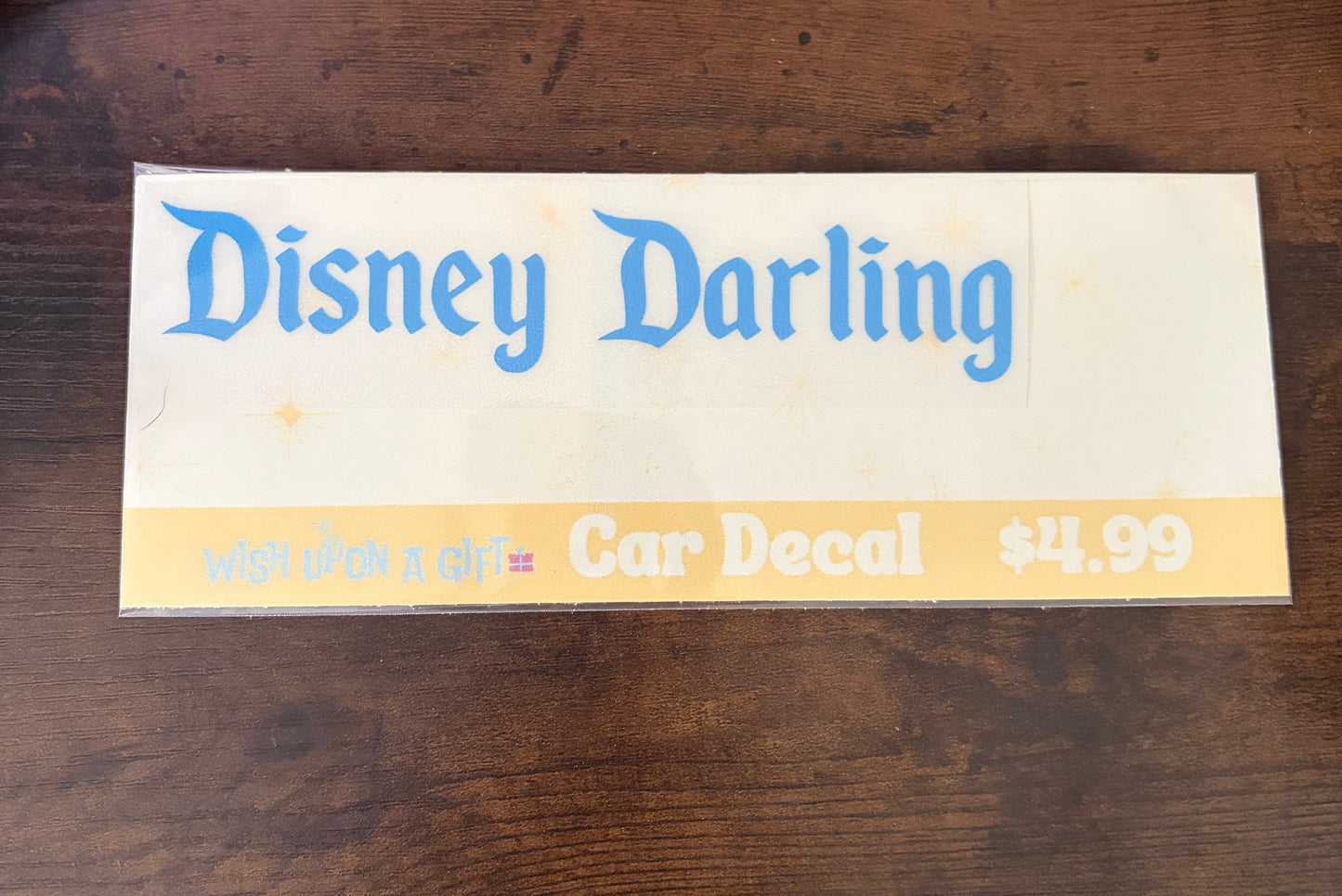 Car decal packaging with graphics of disney darling decal on a wooden surface