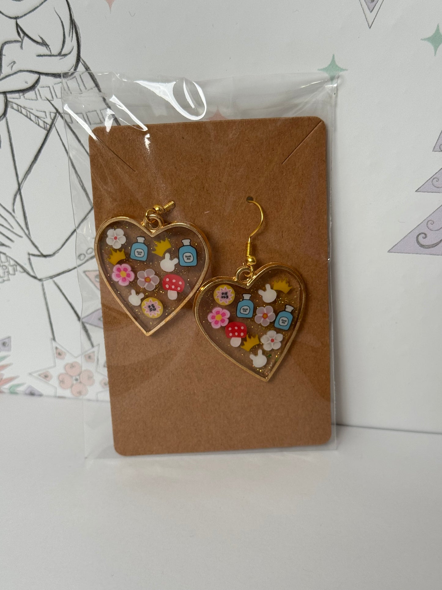 Heart-shaped with sprinkles featuring bunny, crown, eat me and drink me, and mushroom inspired by alice in wonderland earrings