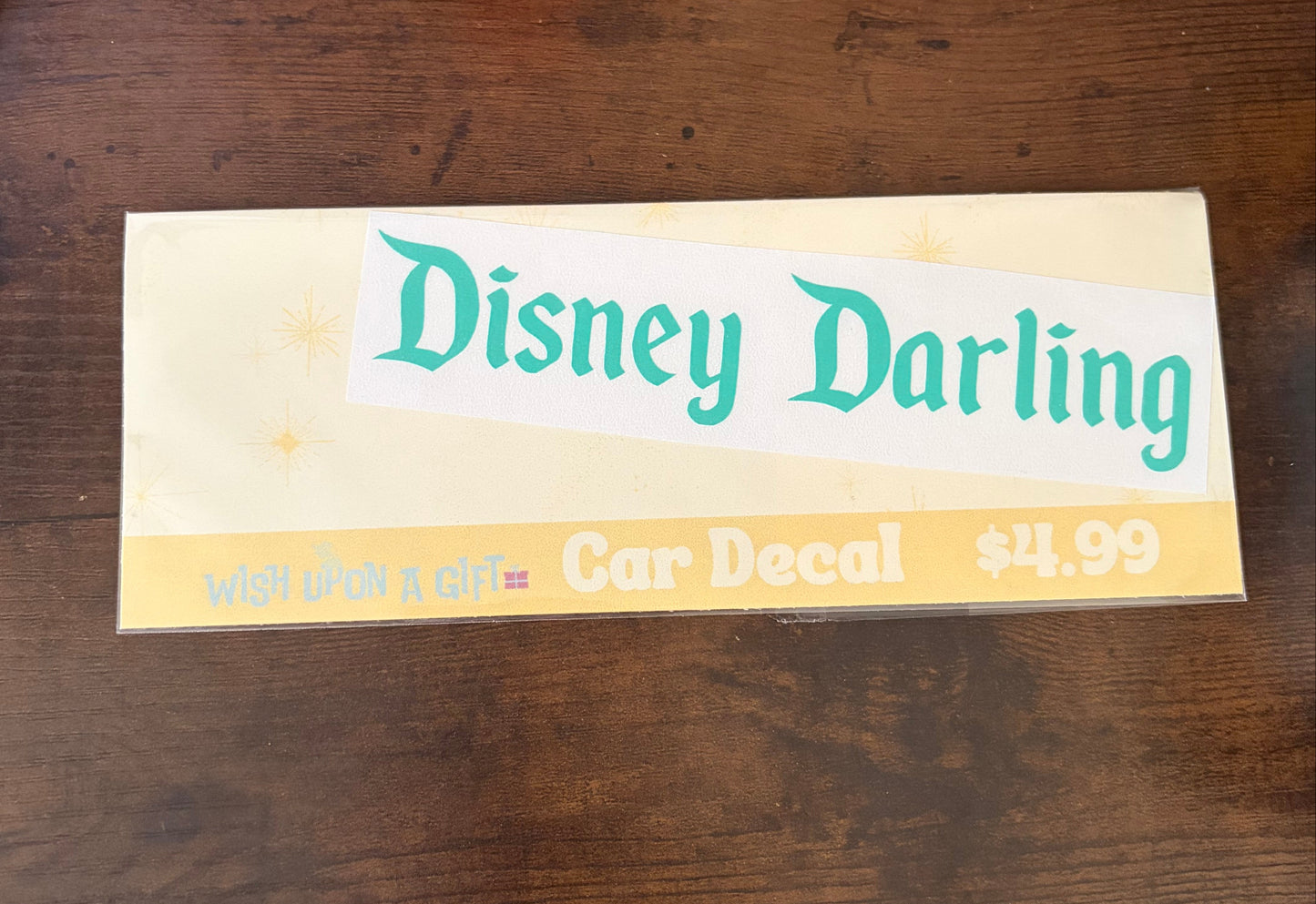 Car decal packaging with graphics of disney darling decal on a wooden surface