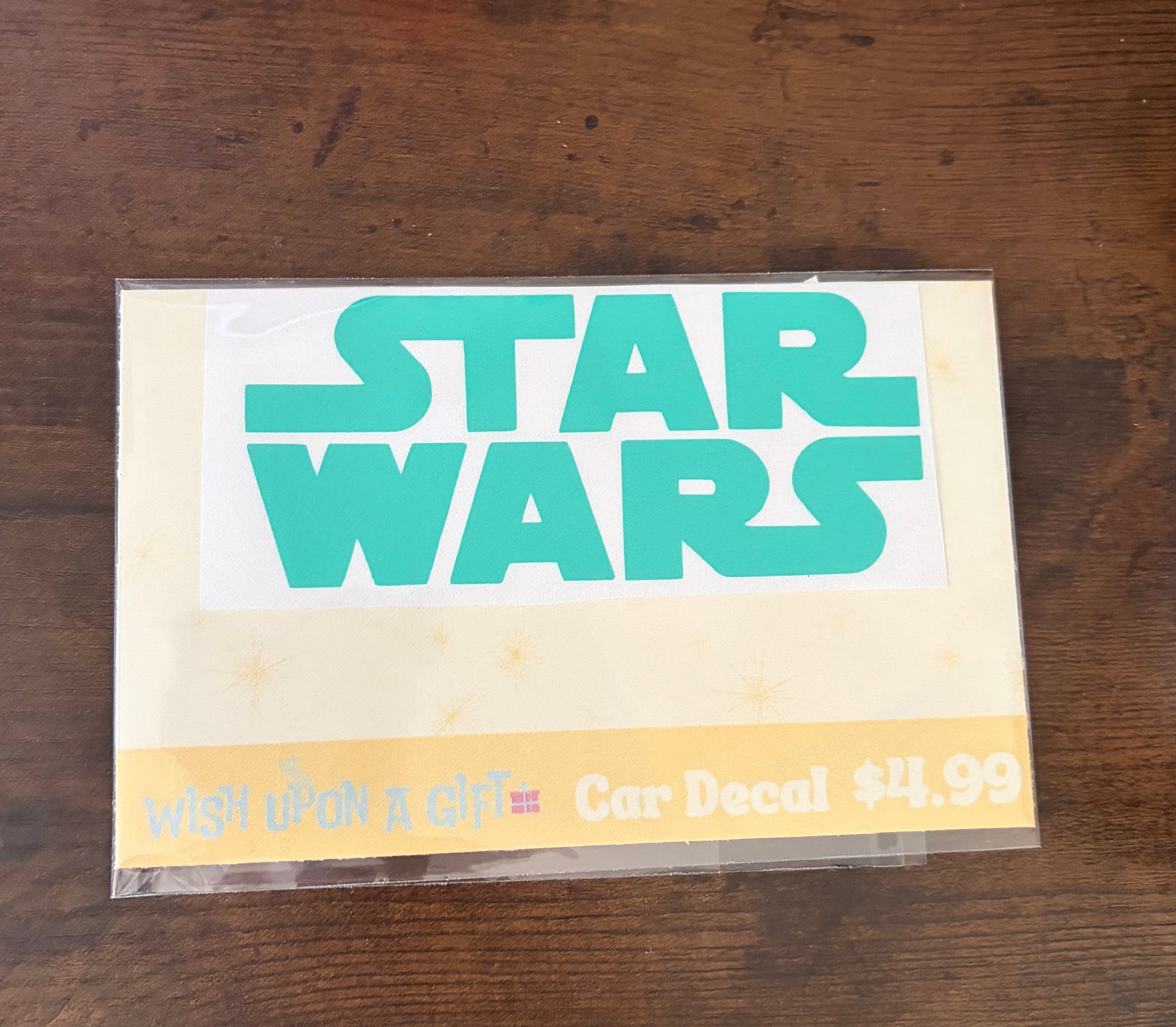 Car decal packaging with graphics of star wars logo on a wooden surface