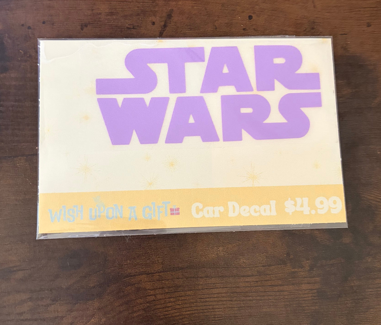 Car decal packaging with graphics of star wars logo on a wooden surface
