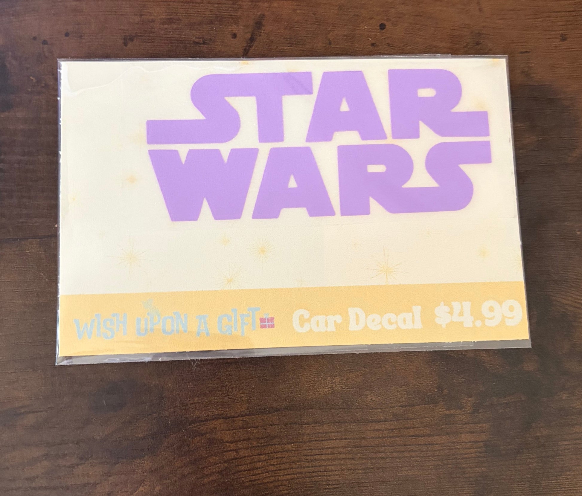 Car decal packaging with graphics of star wars logo on a wooden surface