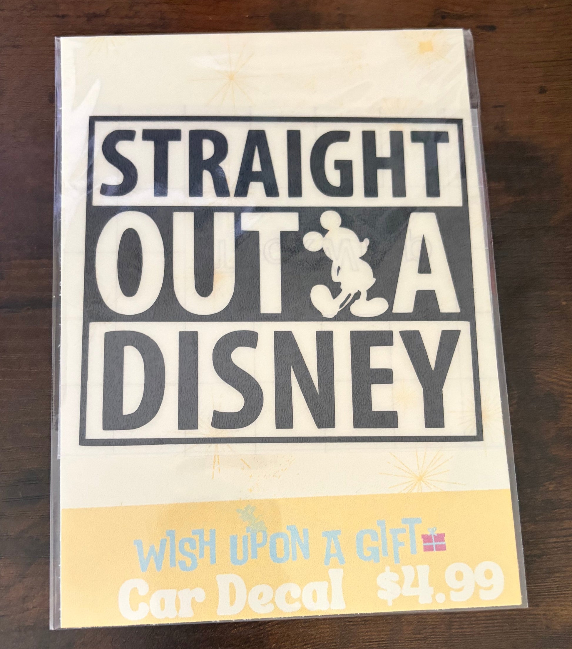 Product packaging with 'Straight Outta Disney' decal on a wooden surface