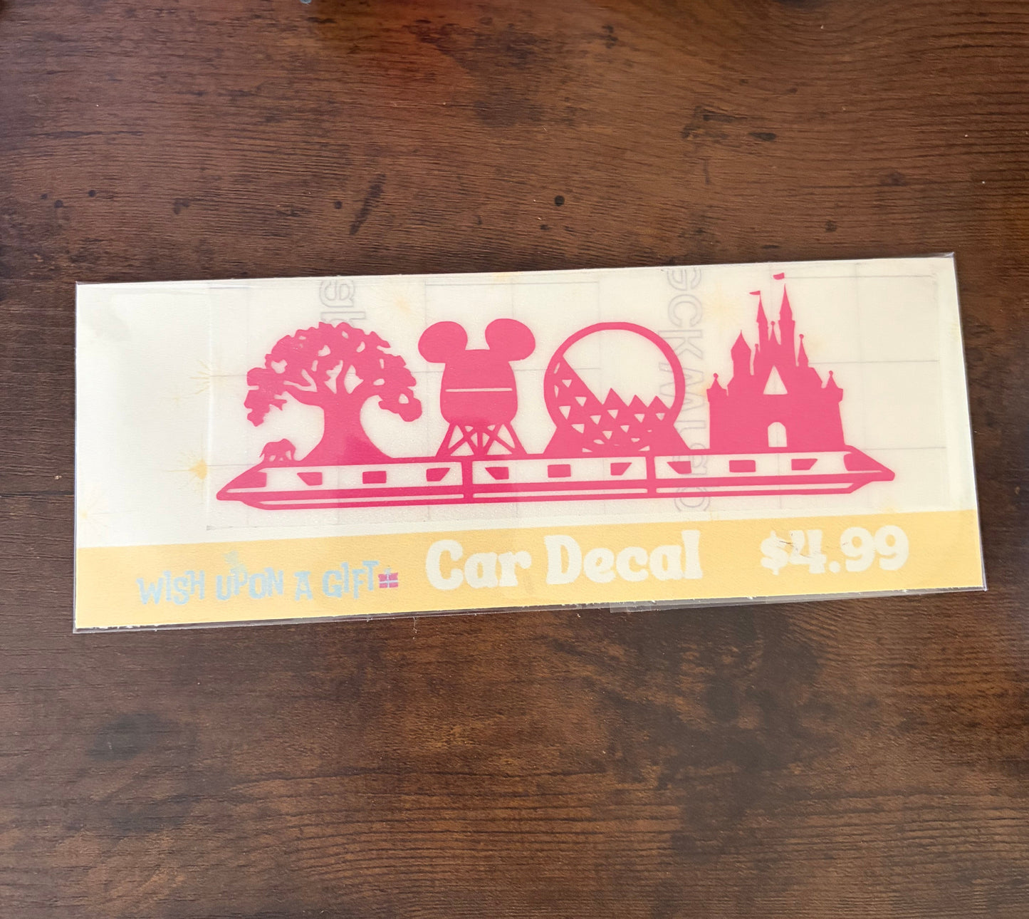 Car decal packaging with graphics of disney skyline and text on a wooden surface