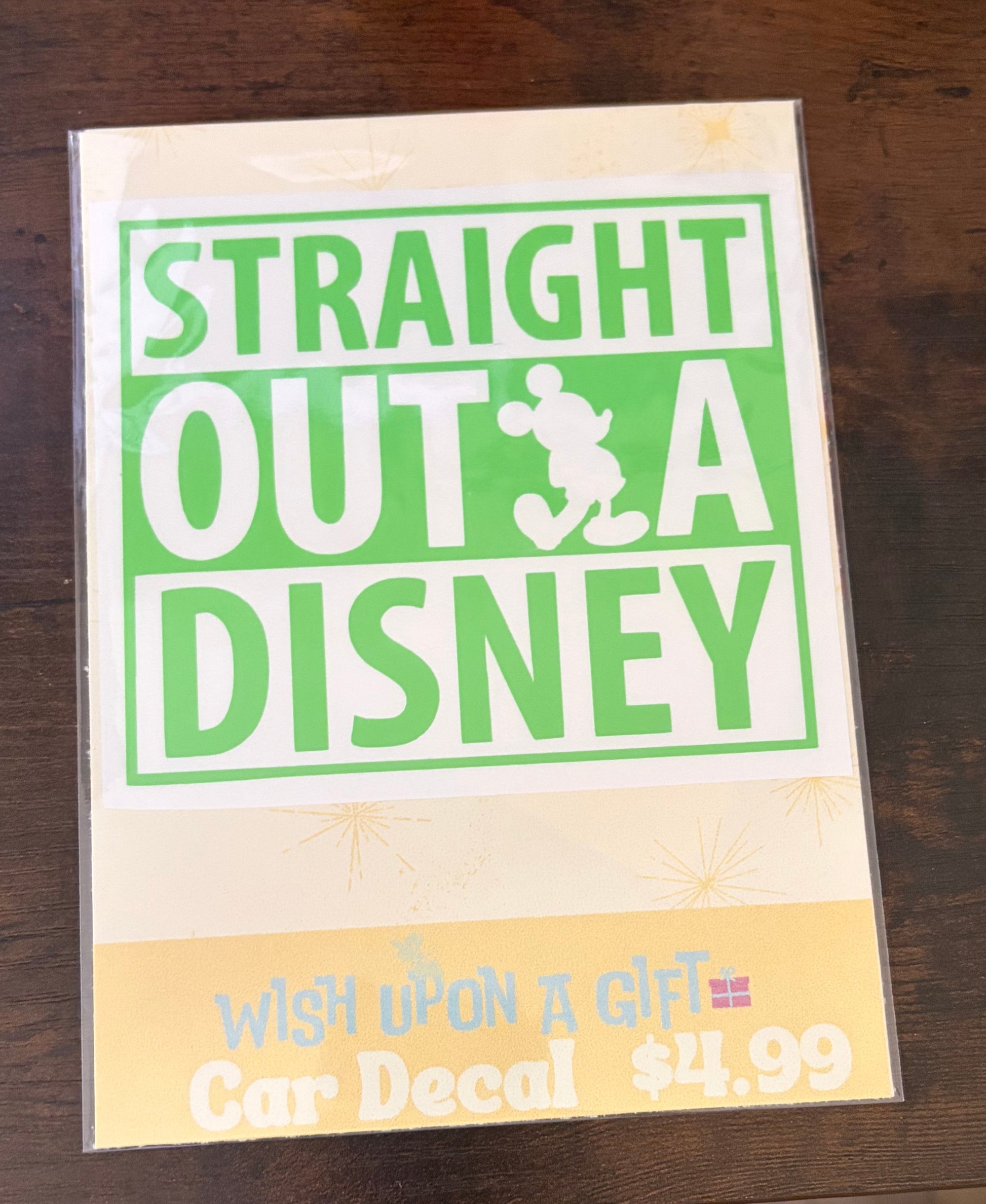 Car decal packaging with 'Straight Outta Disney' decal on a wooden surface.