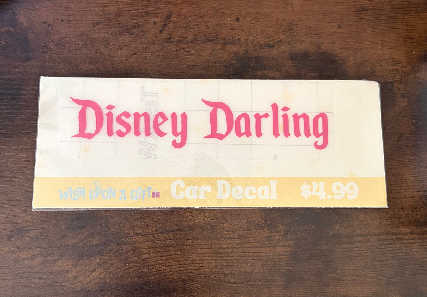 Car decal packaging with graphics of disney darling decal on a wooden surface