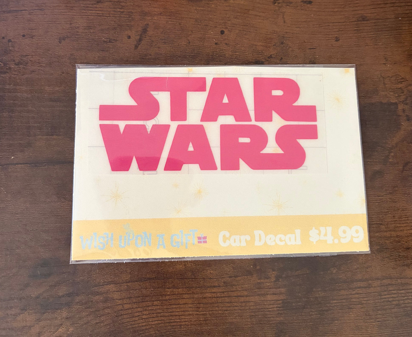 Car decal packaging with graphics of star wars logo on a wooden surface