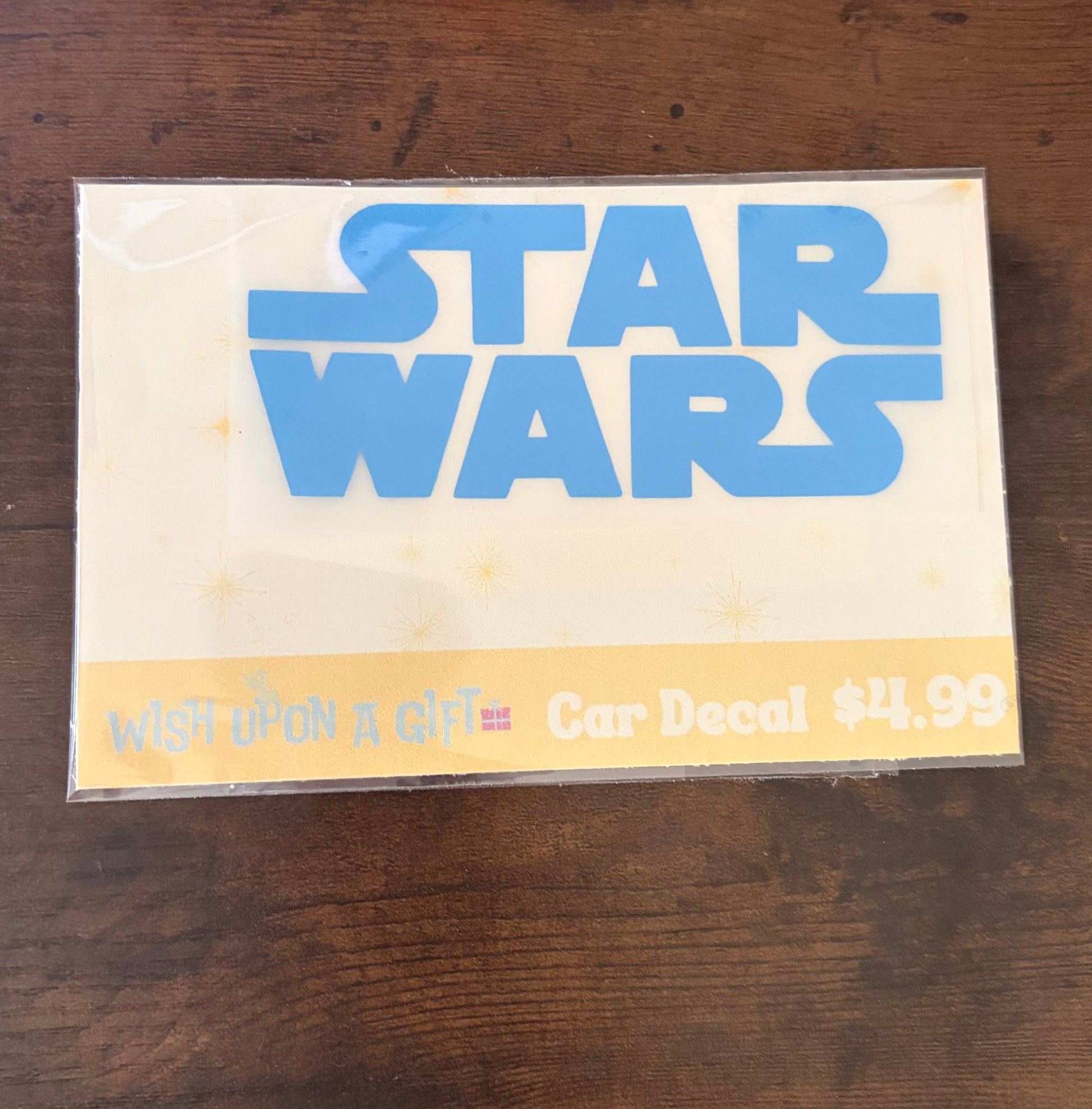 Car decal packaging with graphics of star wars logo on a wooden surface