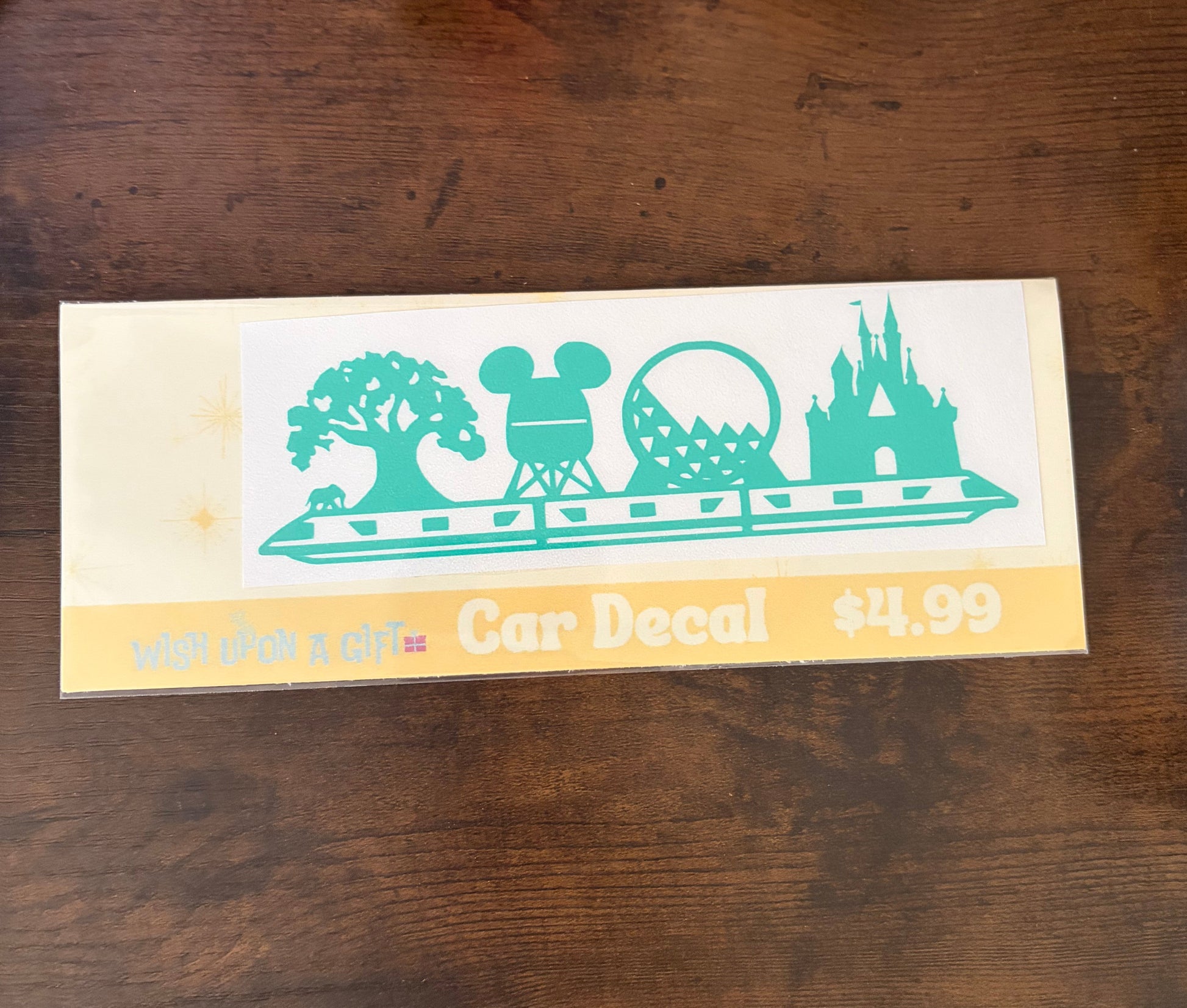 Car decal packaging with graphics of disney skyline and text on a wooden surface