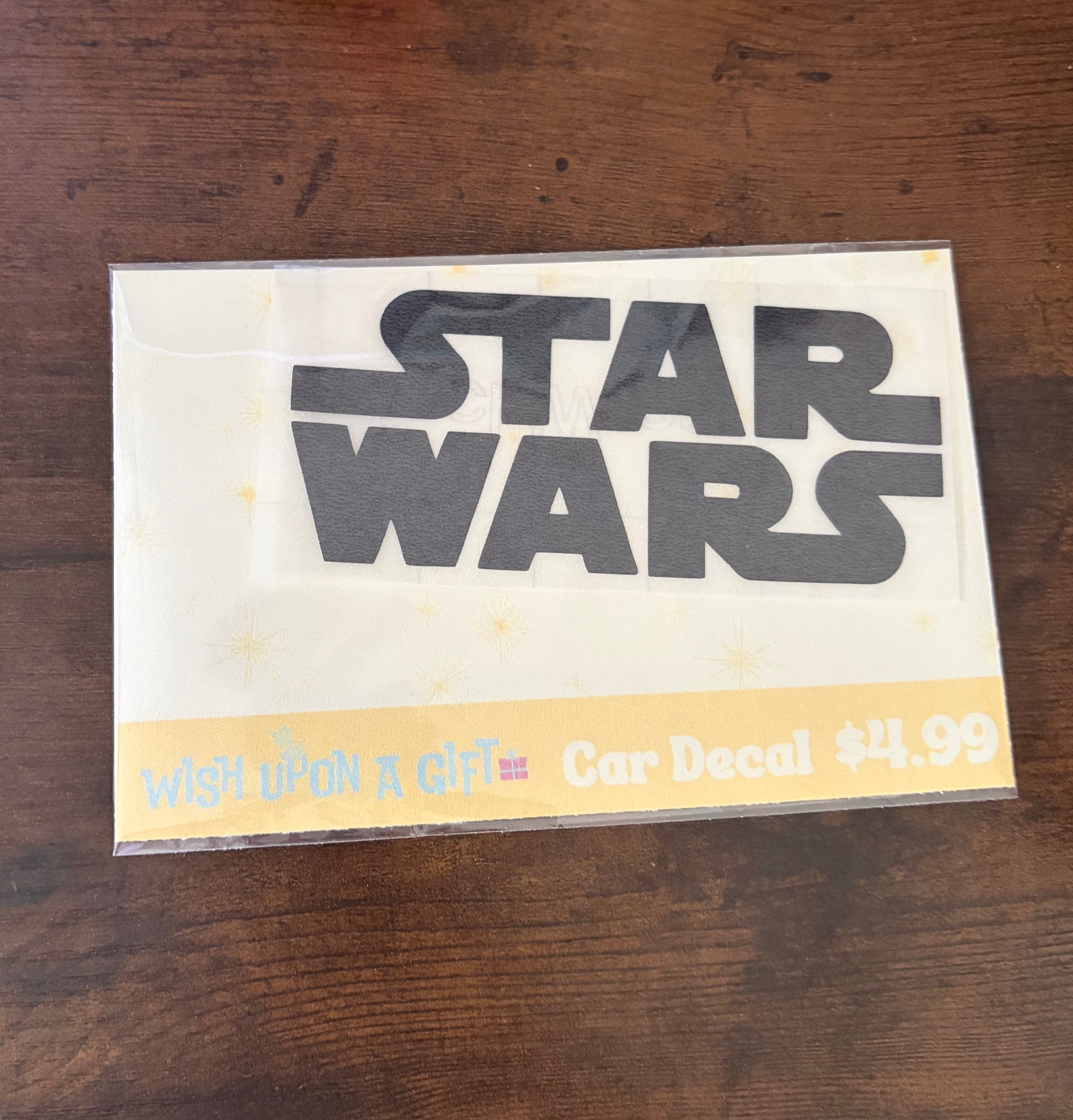 Car decal packaging with graphics of star wars logo on a wooden surface