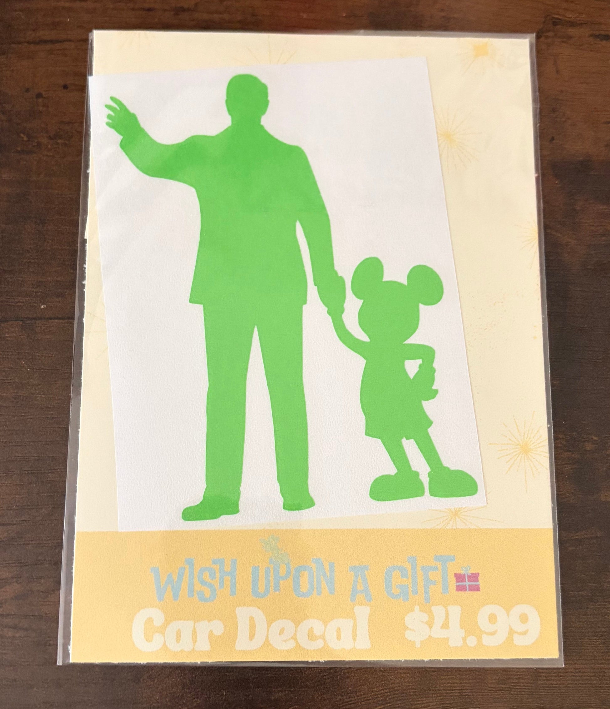 Car decal packaging with graphics of walt disney and mickey mouse and text on a wooden surface