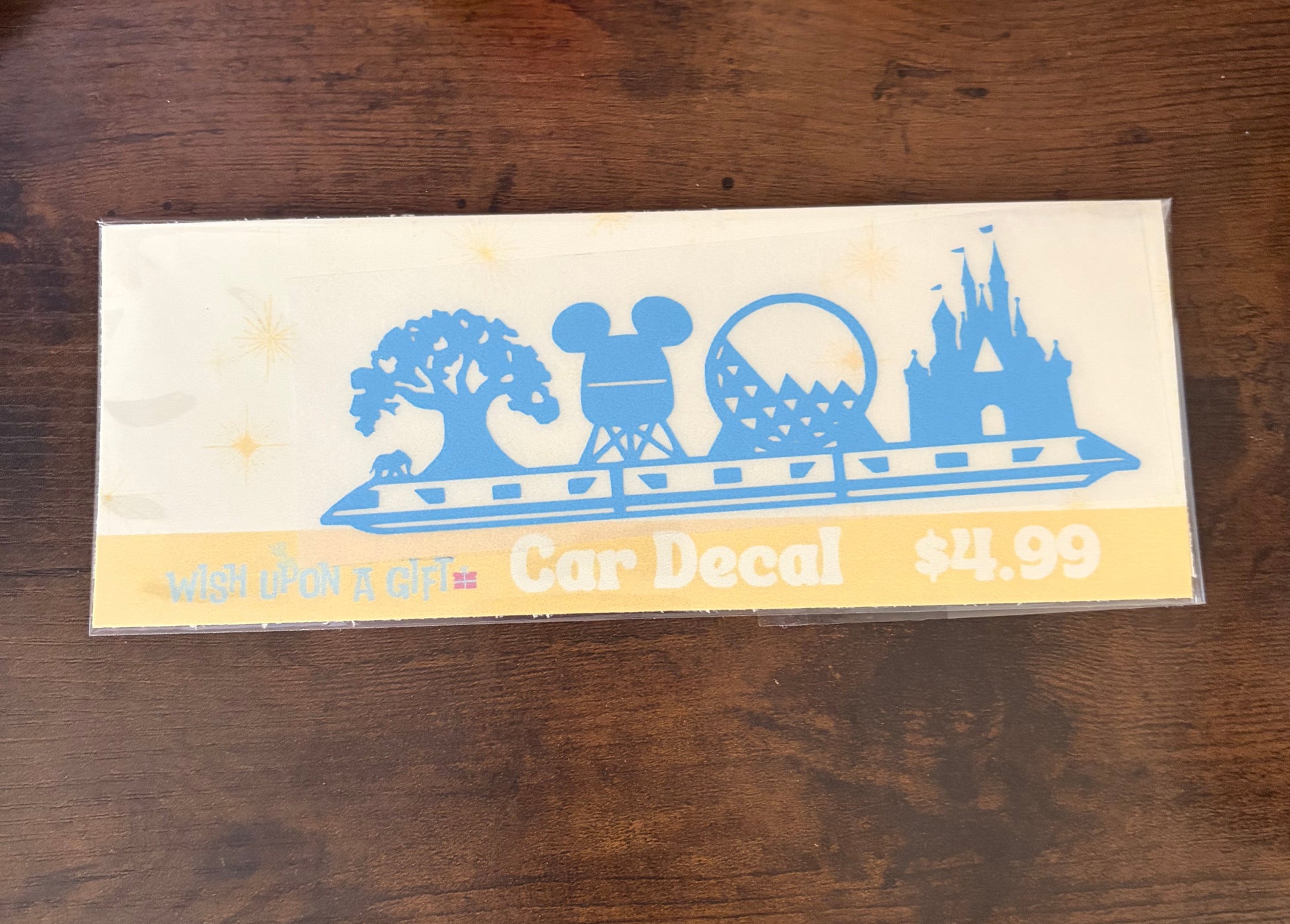Car decal packaging with graphics of disney skyline and text on a wooden surface