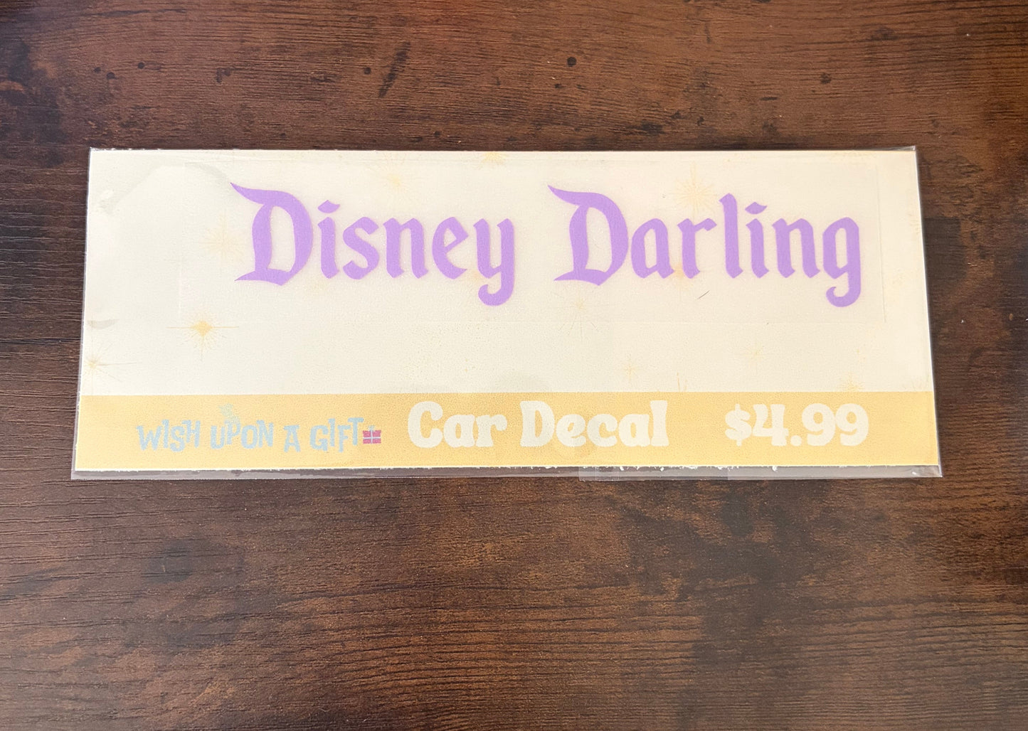 Car decal packaging with graphics of disney darling decal on a wooden surface