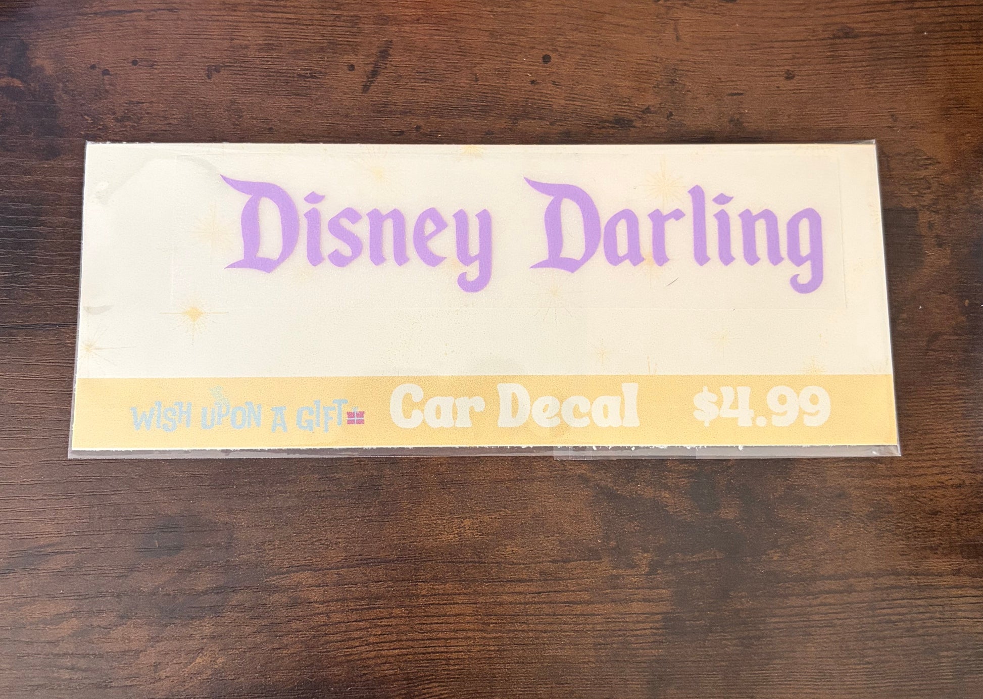 Car decal packaging with graphics of disney darling decal on a wooden surface