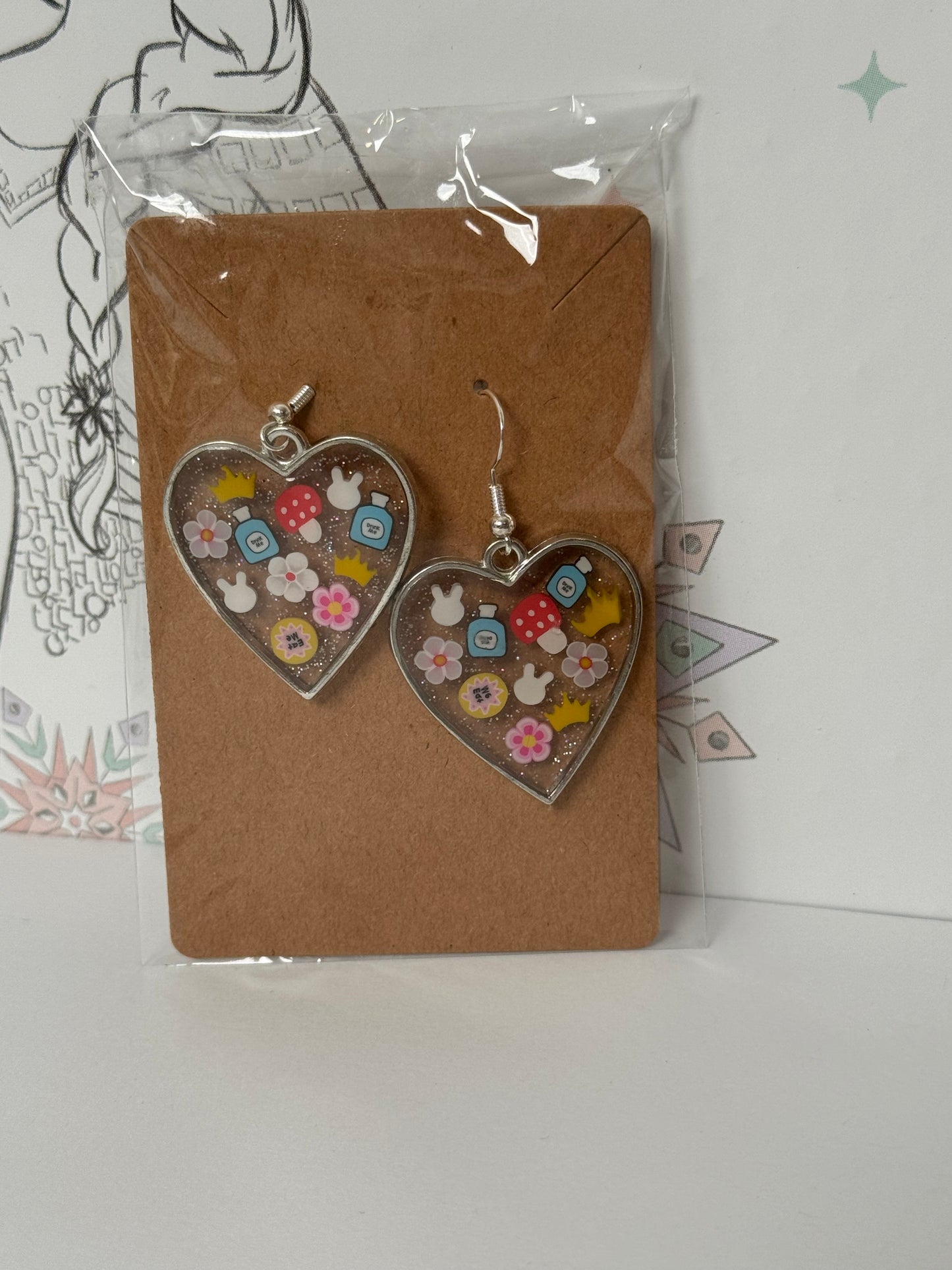 Heart-shaped with sprinkles featuring bunny, crown, eat me and drink me, and mushroom inspired by alice in wonderland earrings
